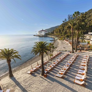 a group of lawn chairs sitting on top of a sandy beach