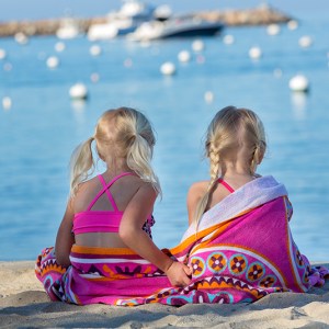 a woman sitting on a beach near a body of water