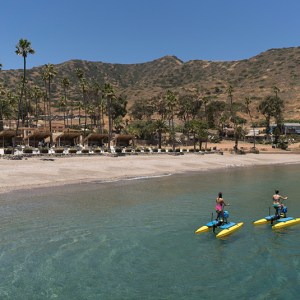 a man riding a motorcycle next to a body of water