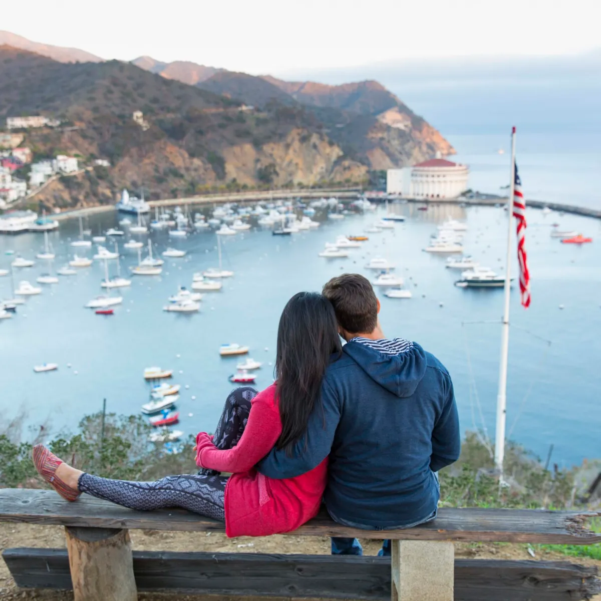 a person sitting on a bench in front of a body of water