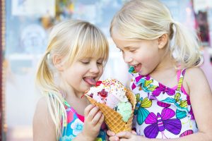 Two young girls eating ice cream in front of Lloyd's of Avalon.