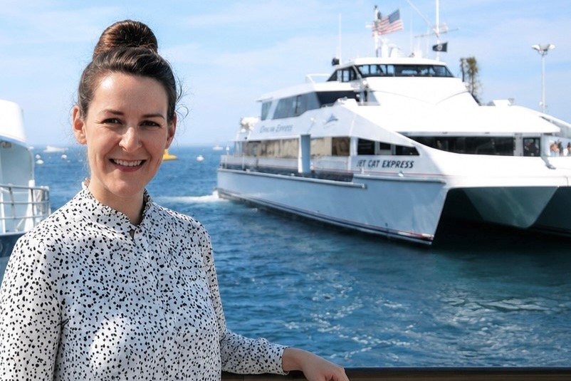 A photo of our employee in Avalon next to a Catalina Express boat. 